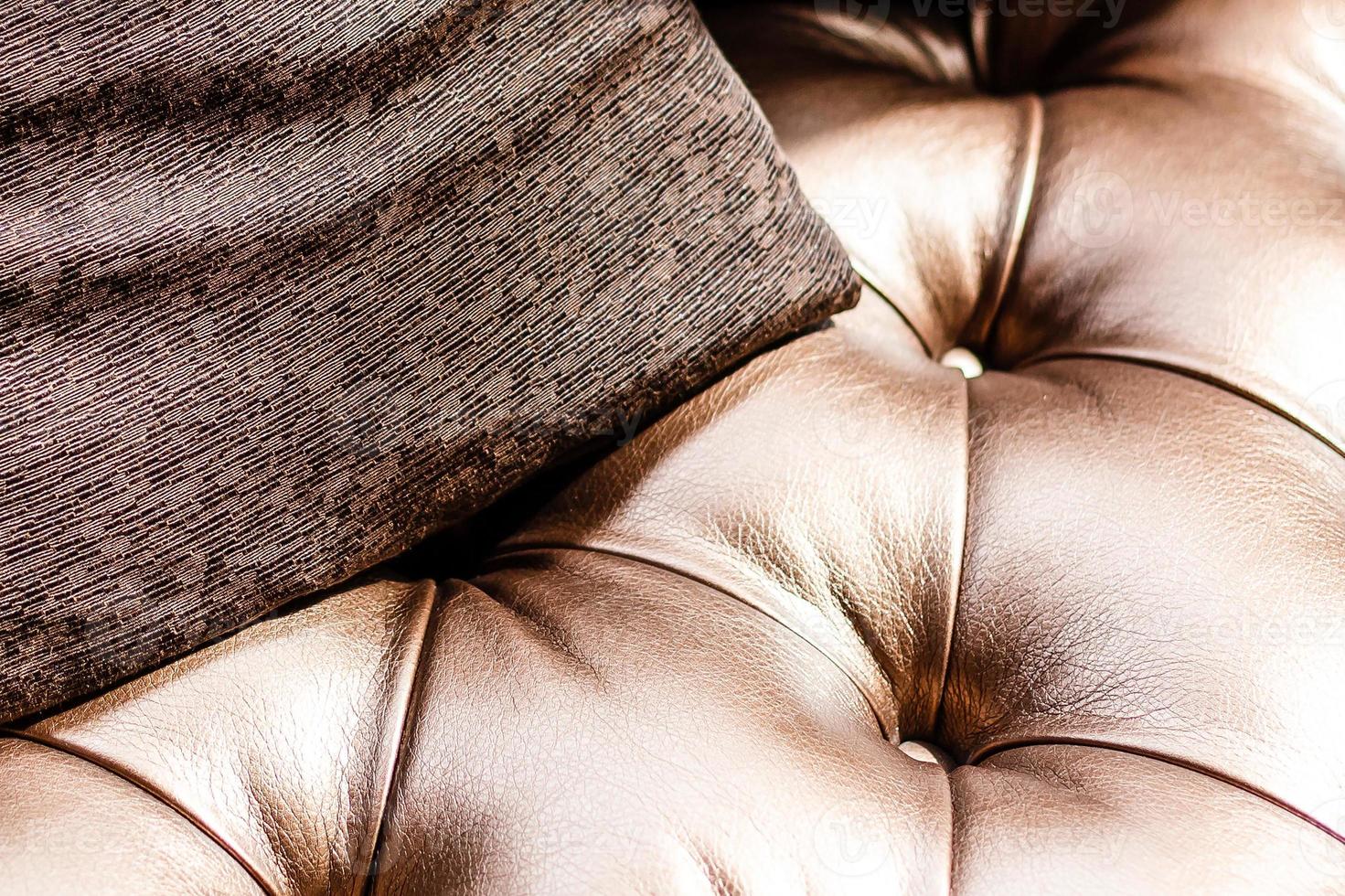 lujoso sofá vintage de cuero marrón con tres cojines de tela. foto