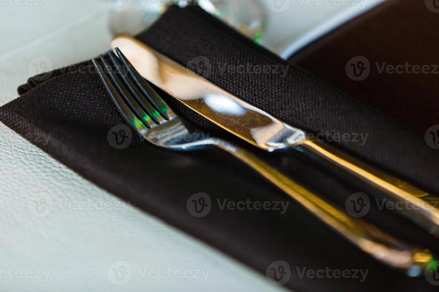 Vintage silverware with a twig of rosemary and empty tag on rustic wooden background Serving in the restaurant fork and knife photo