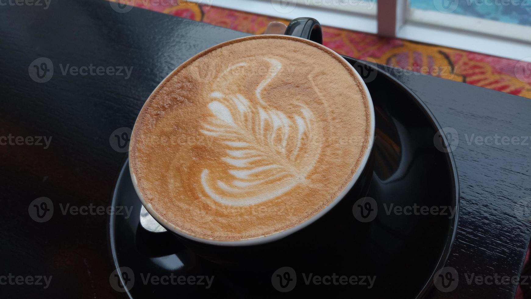 primer plano de arte capuchino en una taza de café negro foto