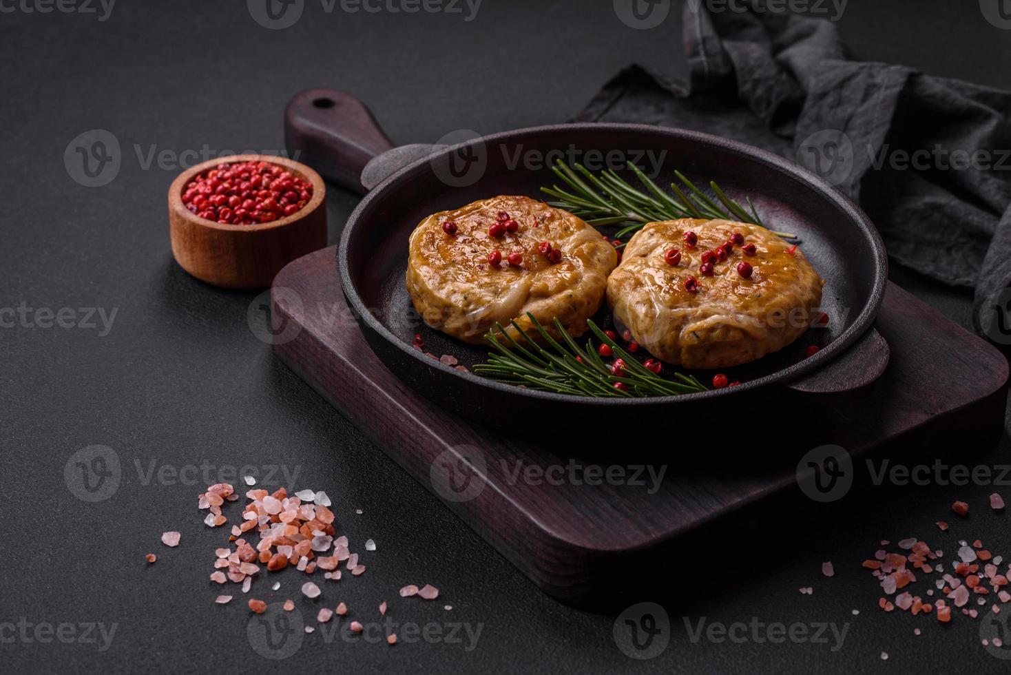 Grilled meatballs with spices and herbs or crepinette on a black plate photo