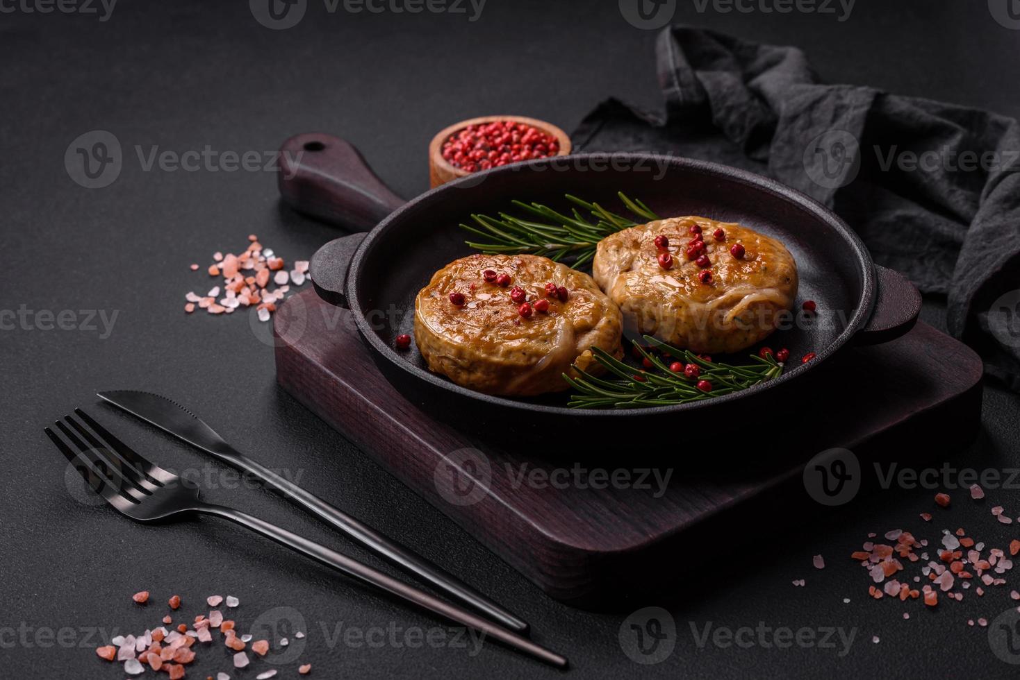 Grilled meatballs with spices and herbs or crepinette on a black plate photo