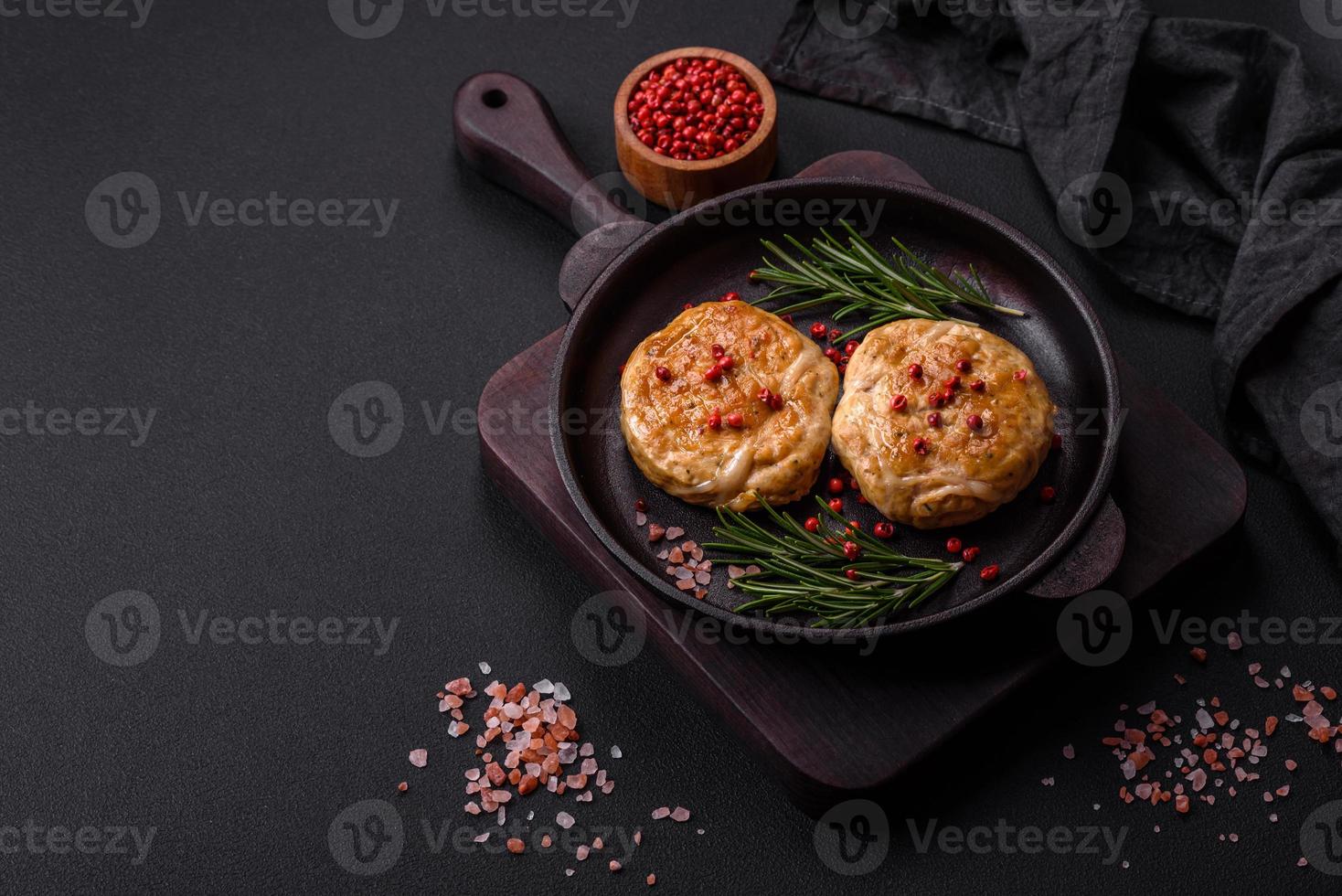 Grilled meatballs with spices and herbs or crepinette on a black plate photo