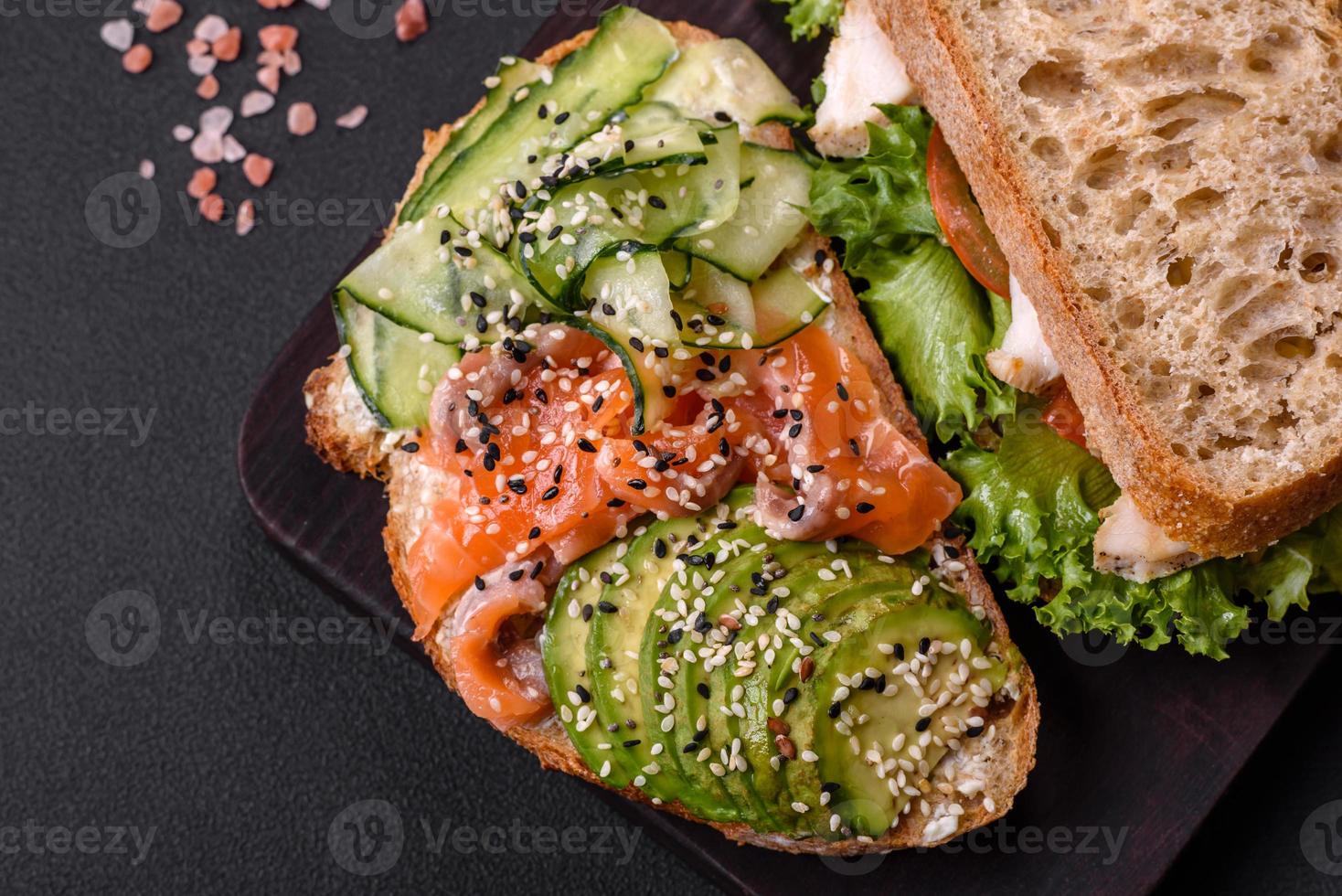 Fresh tasty sandwich with salmon, avocado and sesame and flax seeds photo