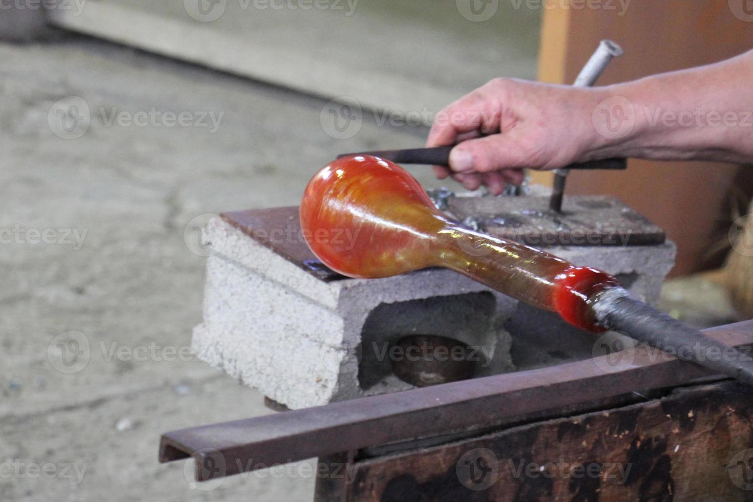 The master works with glass at a glass factory. photo