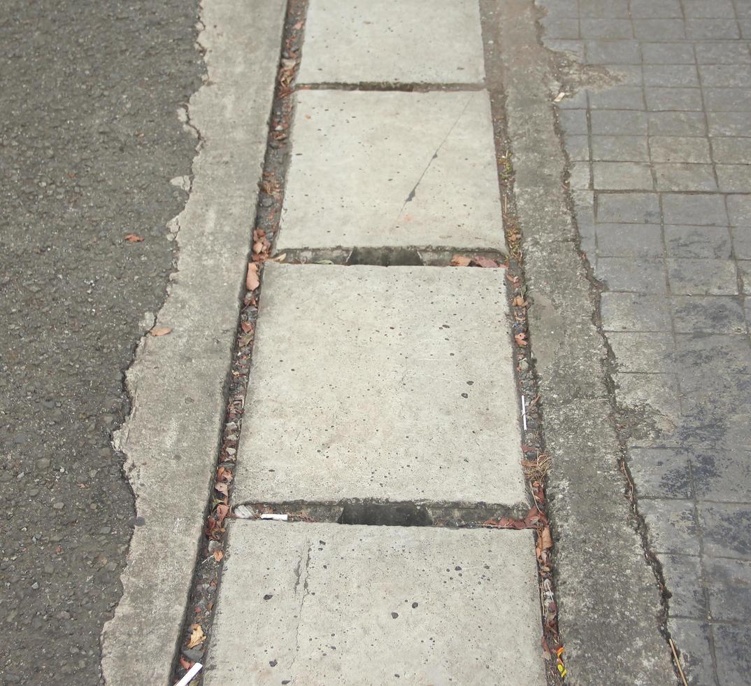 drenaje de la vía fluvial de la acera de la ciudad con material de hormigón de piedra. pavimentación de vías urbanas. foto