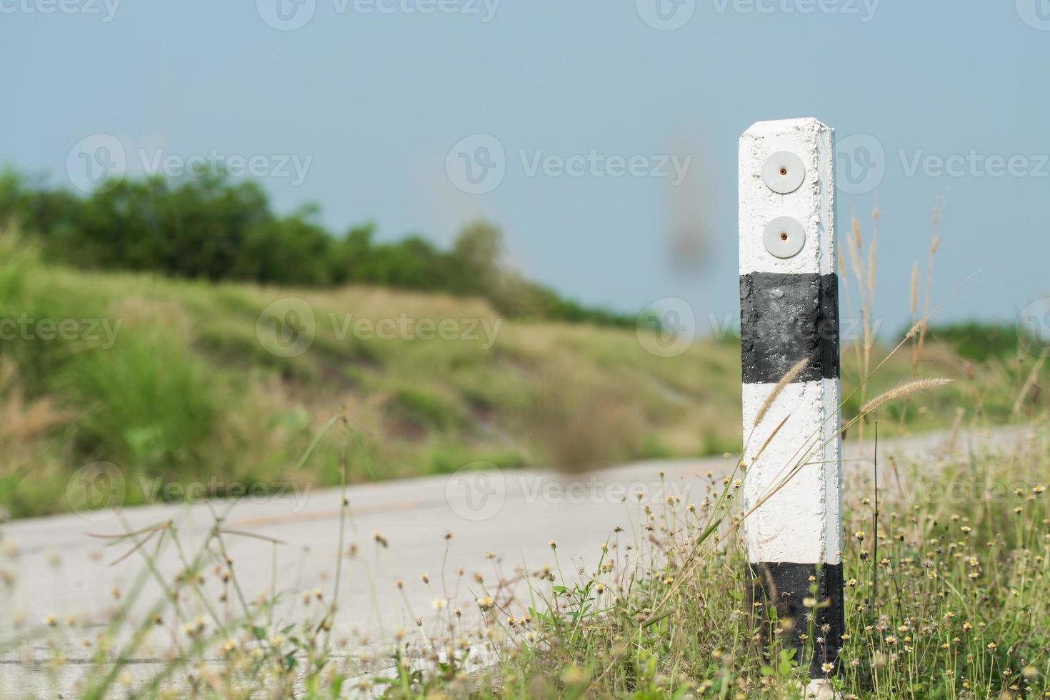 The guide post is right on the road warns car users to use the road. Perseverance concept photo