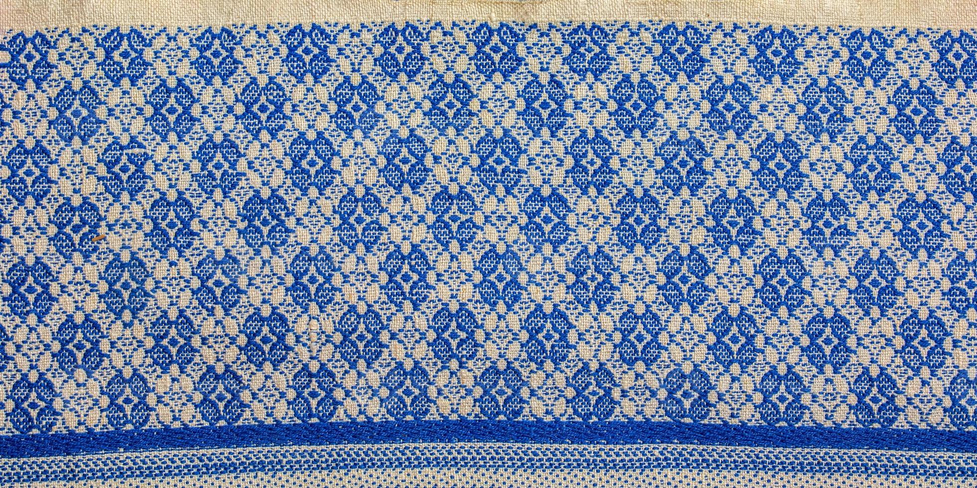 A fragment of the texture of a white-blue tablecloth made in the 1960s in Ukraine. Traditional national ornament. photo