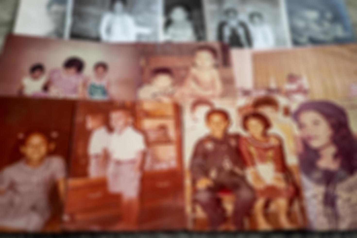 A close-up, blurry, out-of-focus background of old family photos in black and white and sepia.