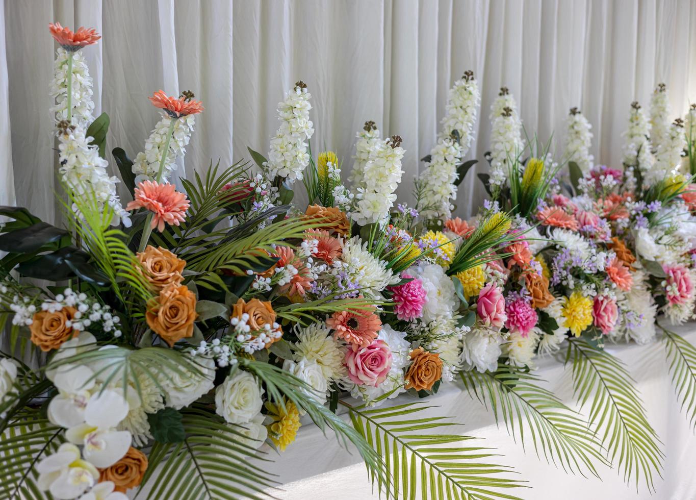 Close-up view of rows of white bouquets, roses and chrysanthemums of various colors. photo