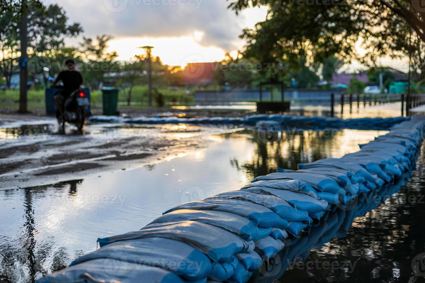 Blue sacks filled with sand are stacked in rows to form dams to prevent