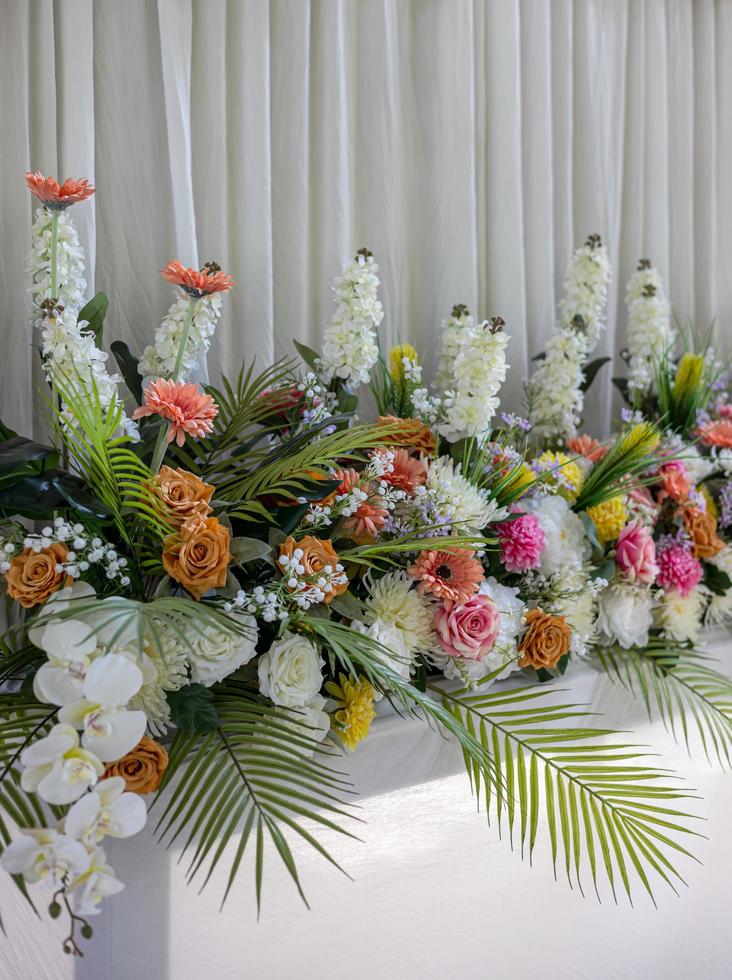 Close-up view of rows of white bouquets, roses and chrysanthemums of various colors. photo