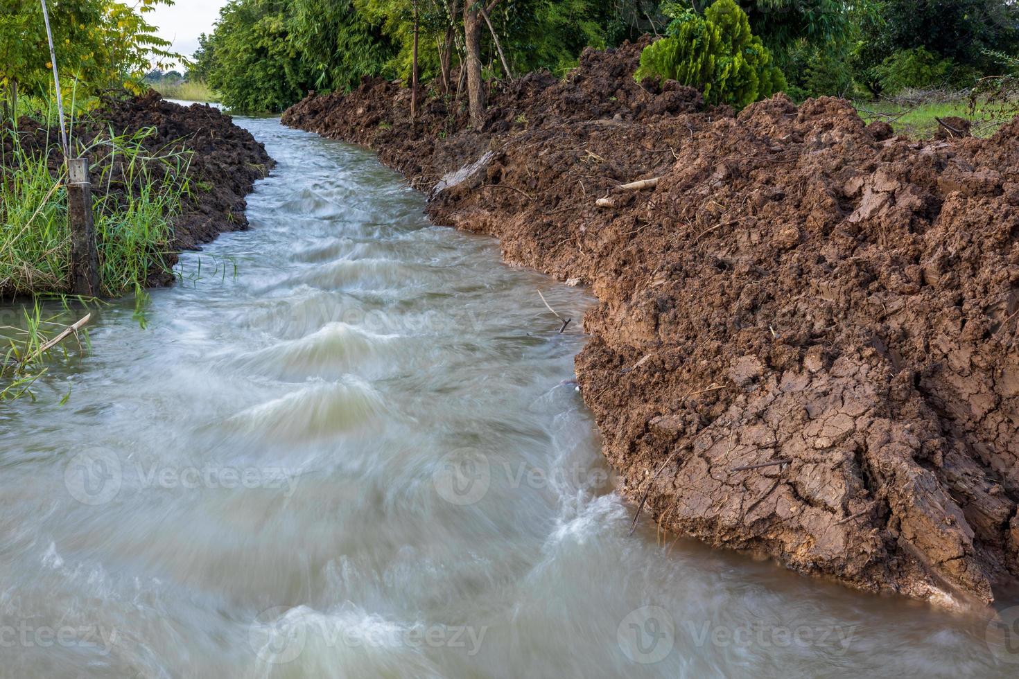 The view of the water rushing through the mounds of soil that have been dug up. photo