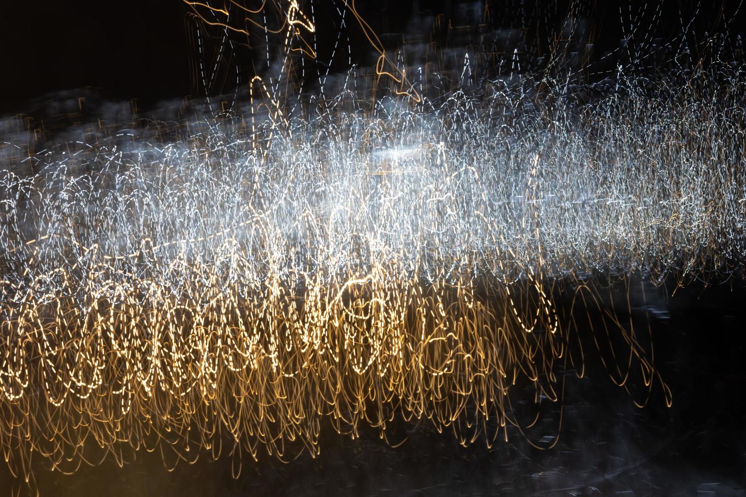 un fondo abstracto con rayas caóticas de luz blanca y amarilla de una larga exposición. foto