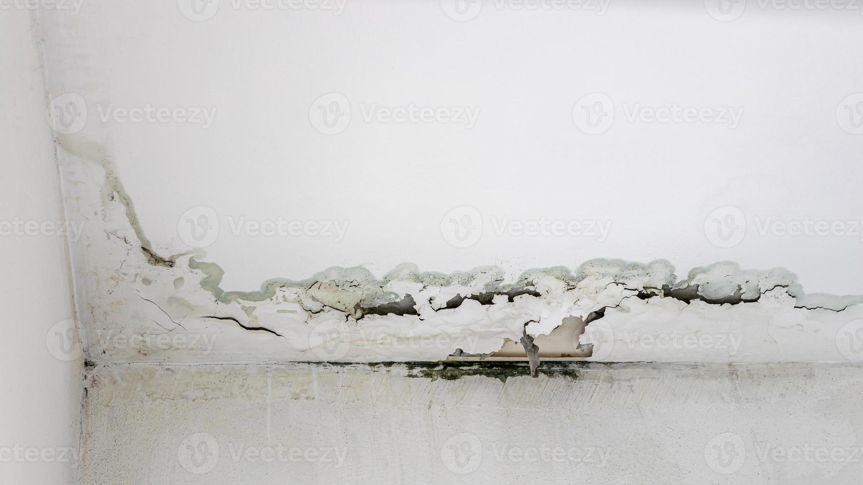 White concrete wall and ceiling background in the corner of the indoor room which has been peeling and damaged. photo