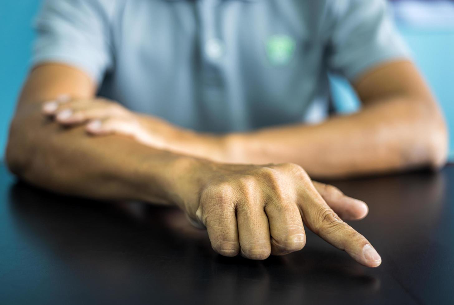 Close-up front view of both hands of a thai man wearing gray shirt making various gestures. photo