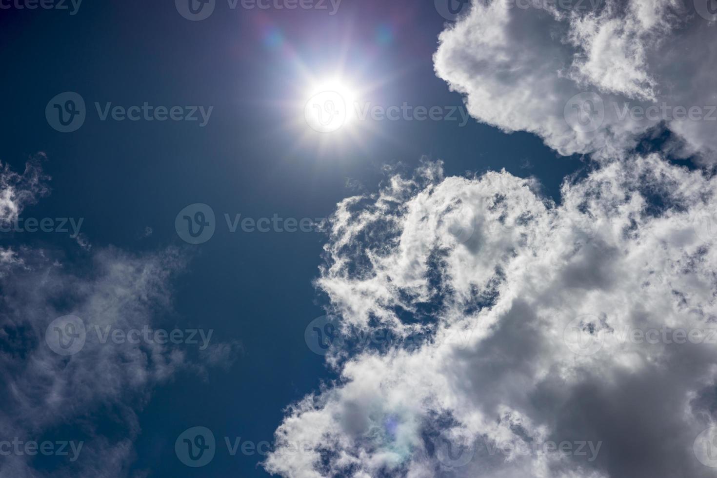 Landscape background with white clouds drifting near the bright rays of the sun. photo