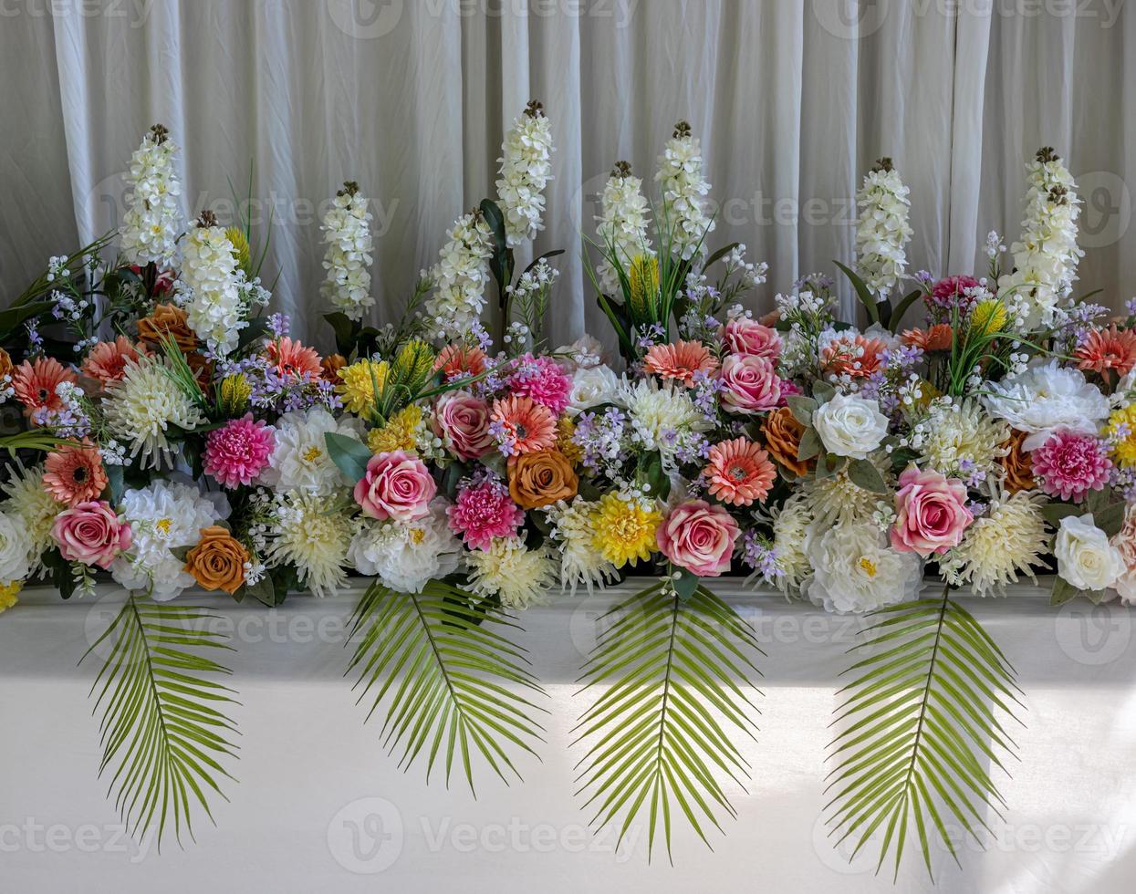 Close-up view of rows of white bouquets, roses and chrysanthemums of various colors. photo