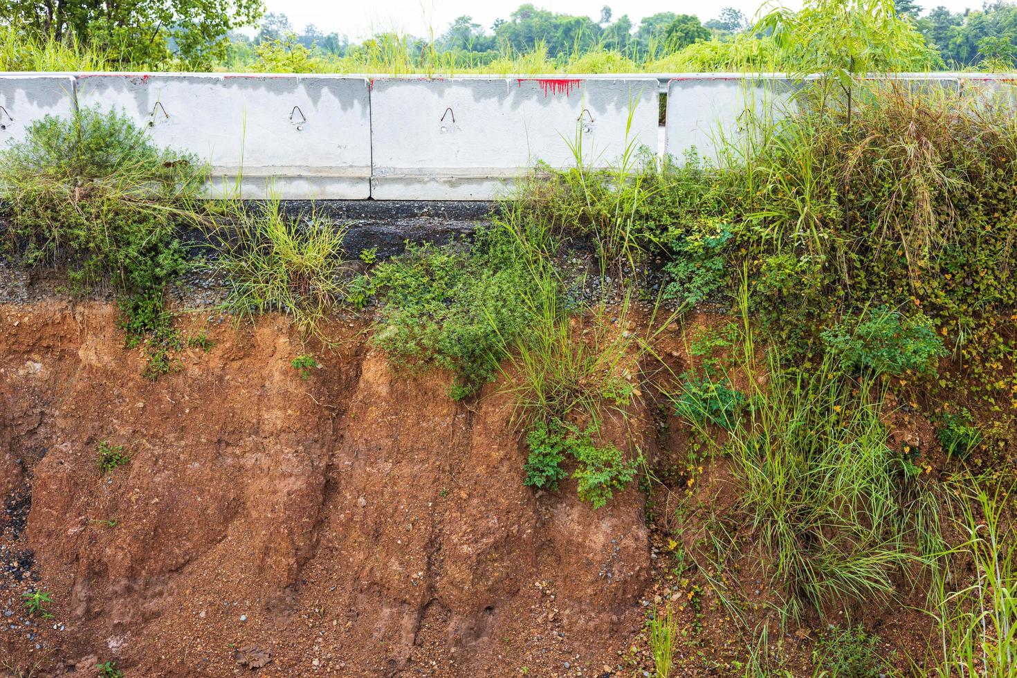 A side view of the sandstone soil beneath the asphalt road which was eroded by water. photo