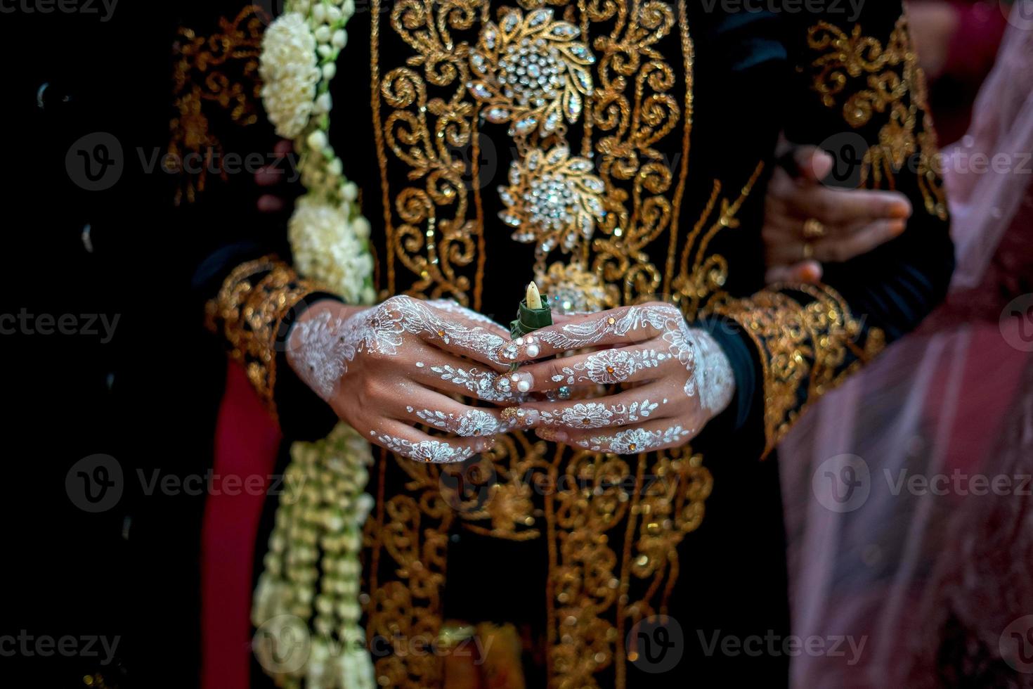 bella novia vestida de novia con collar de flores de jazmín y magnolia para una ceremonia de boda tradicional en indonesia foto