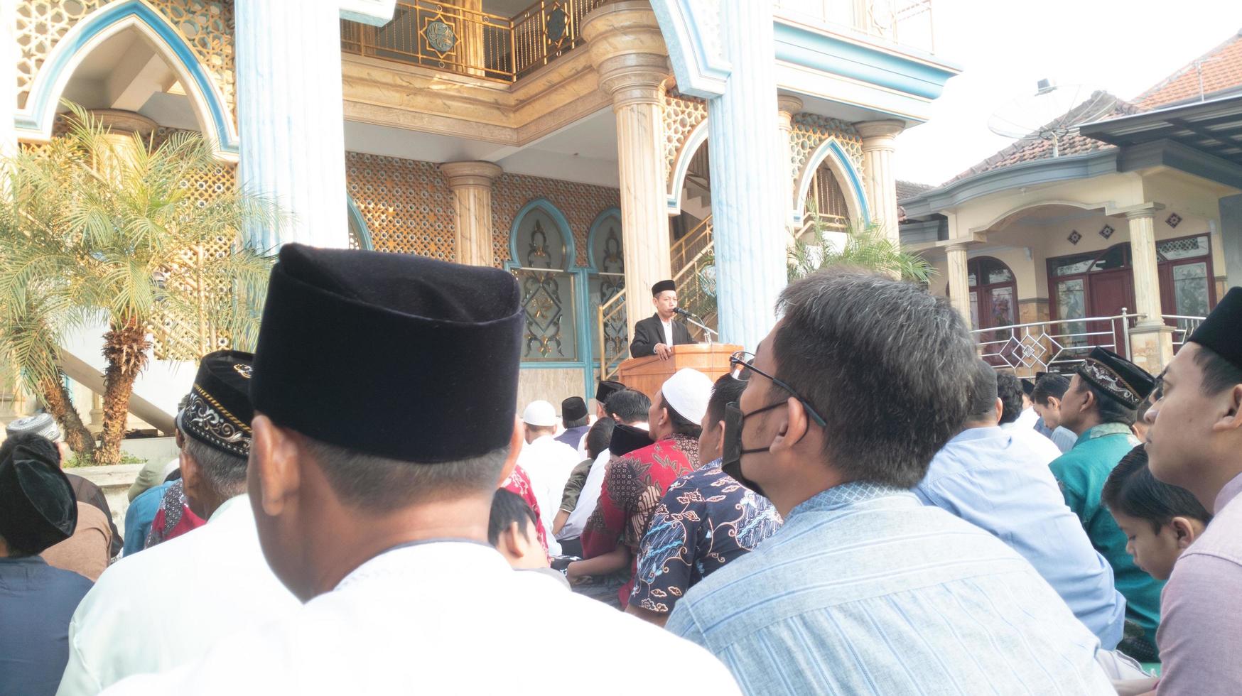gresik, indonesia, 2022 - you can see people focusing on listening to lectures after carrying out the Eid al-Adha prayers photo