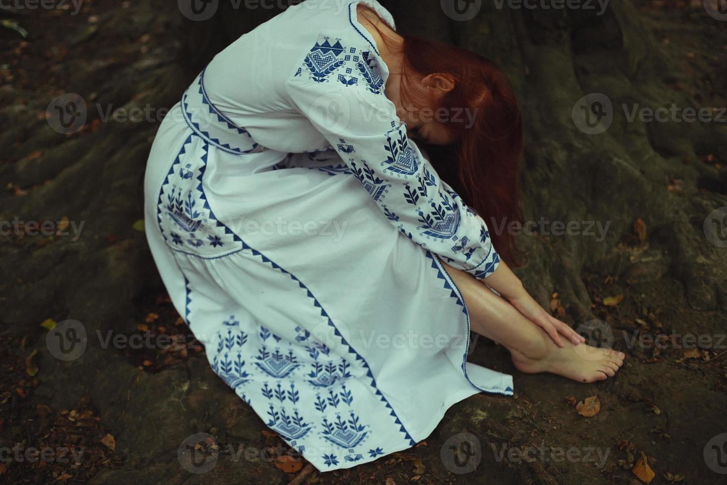 Close up tired barefoot woman in embroidery dress concept photo