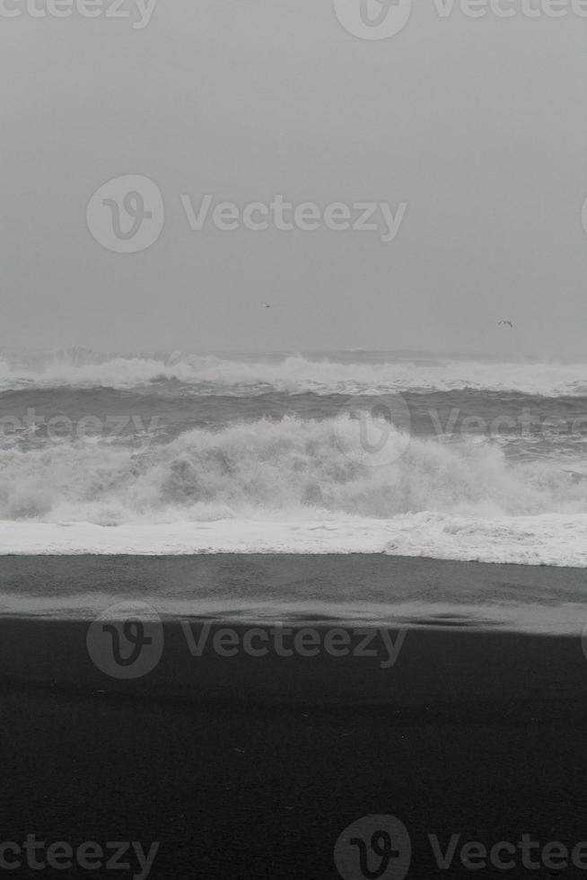 Wave breaking on empty beach monochrome landscape photo