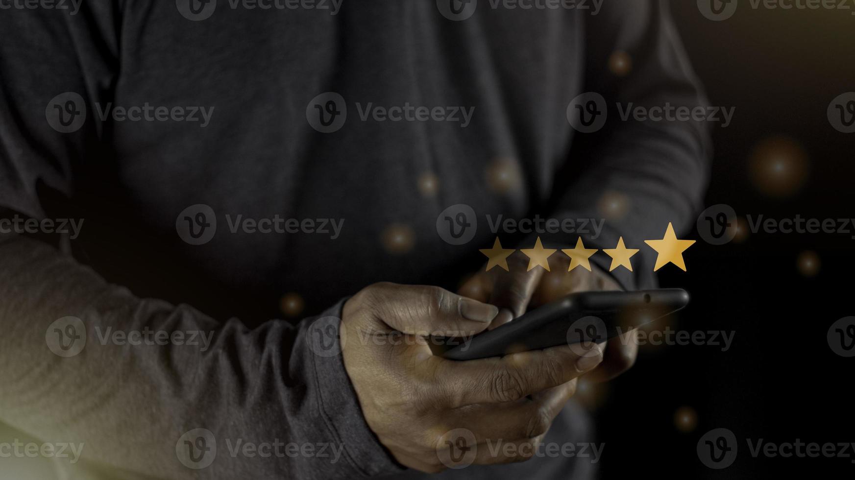 Satisfaction close up on customer man hand pressing on screen with five star rating feedback icon and press level excellent rank for giving best score point to review the service concept photo