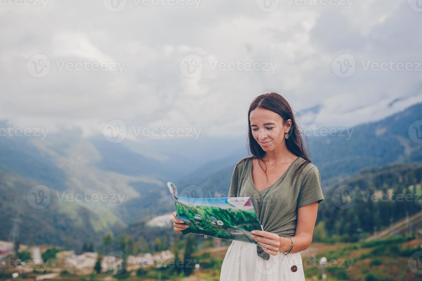 Happy young woman in mountains in the background of fog photo