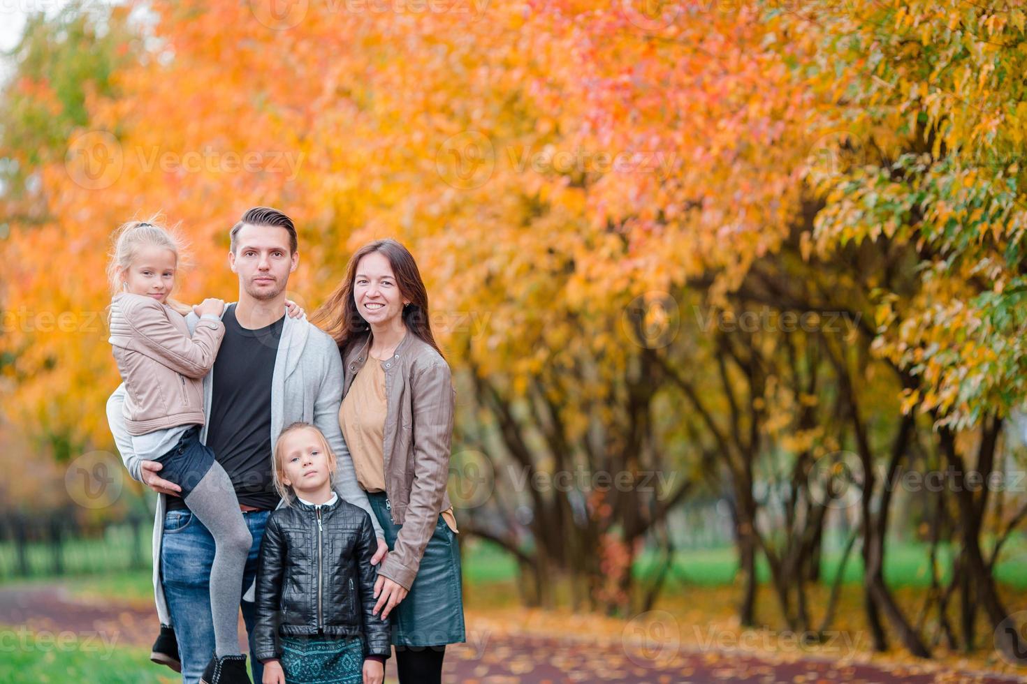 Portrait of happy family of four in autumn day photo