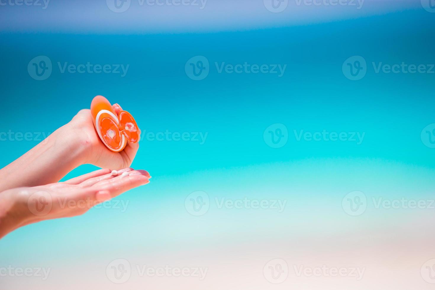 Closeup suncream bottle background turquoise water photo