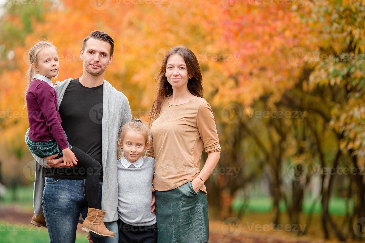 retrato de familia feliz de cuatro en día de otoño foto