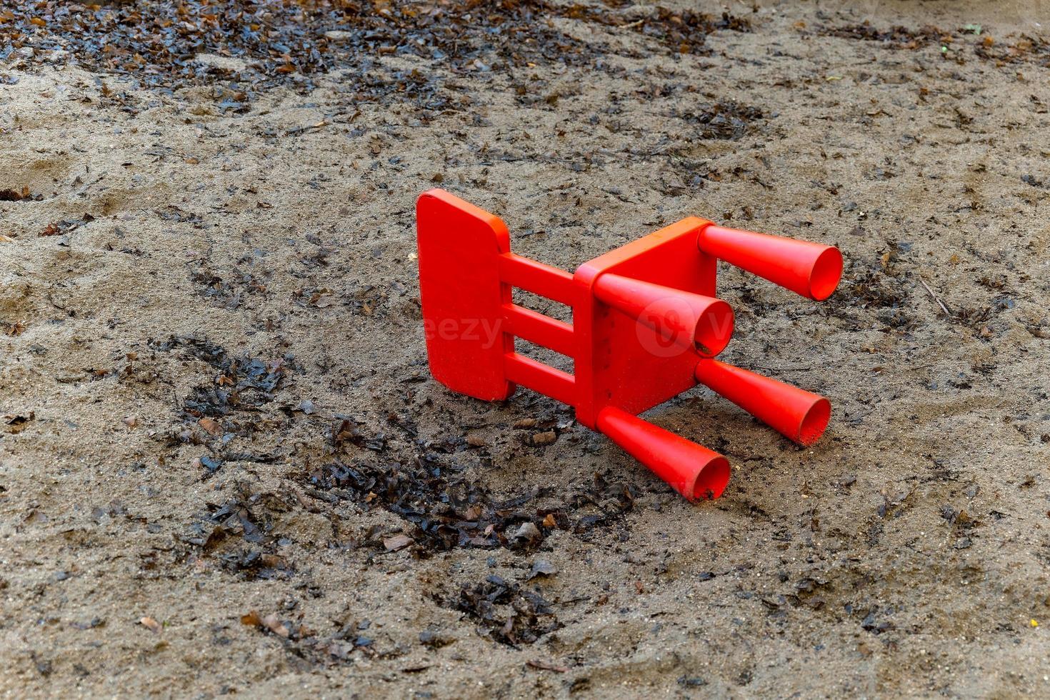 a small red chair in a sandbox photo