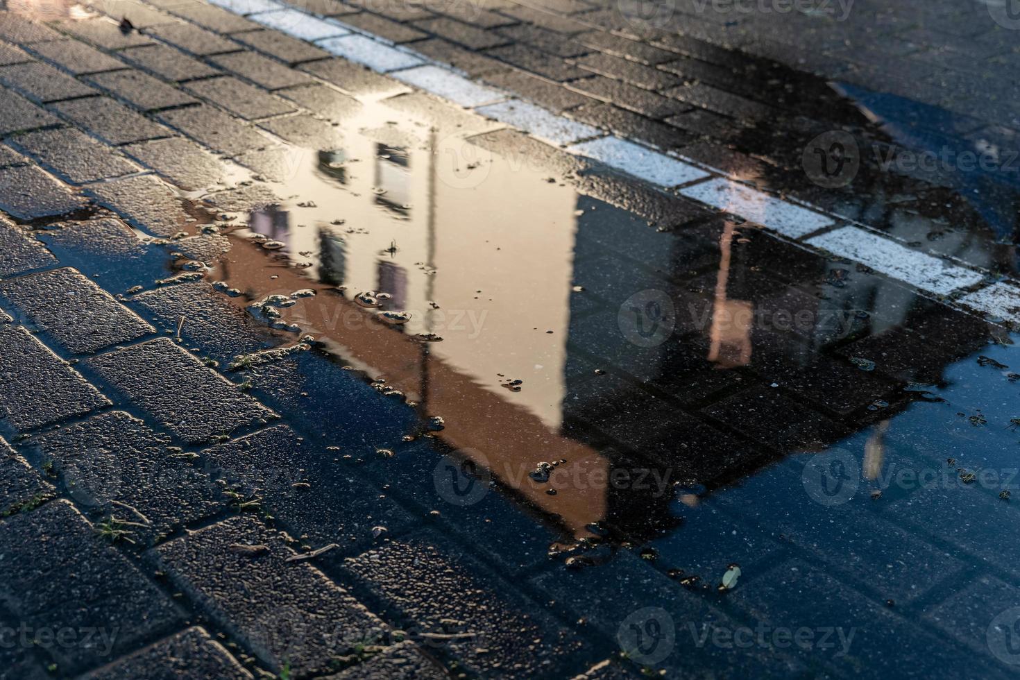 puddle in which an apartment building is reflected photo