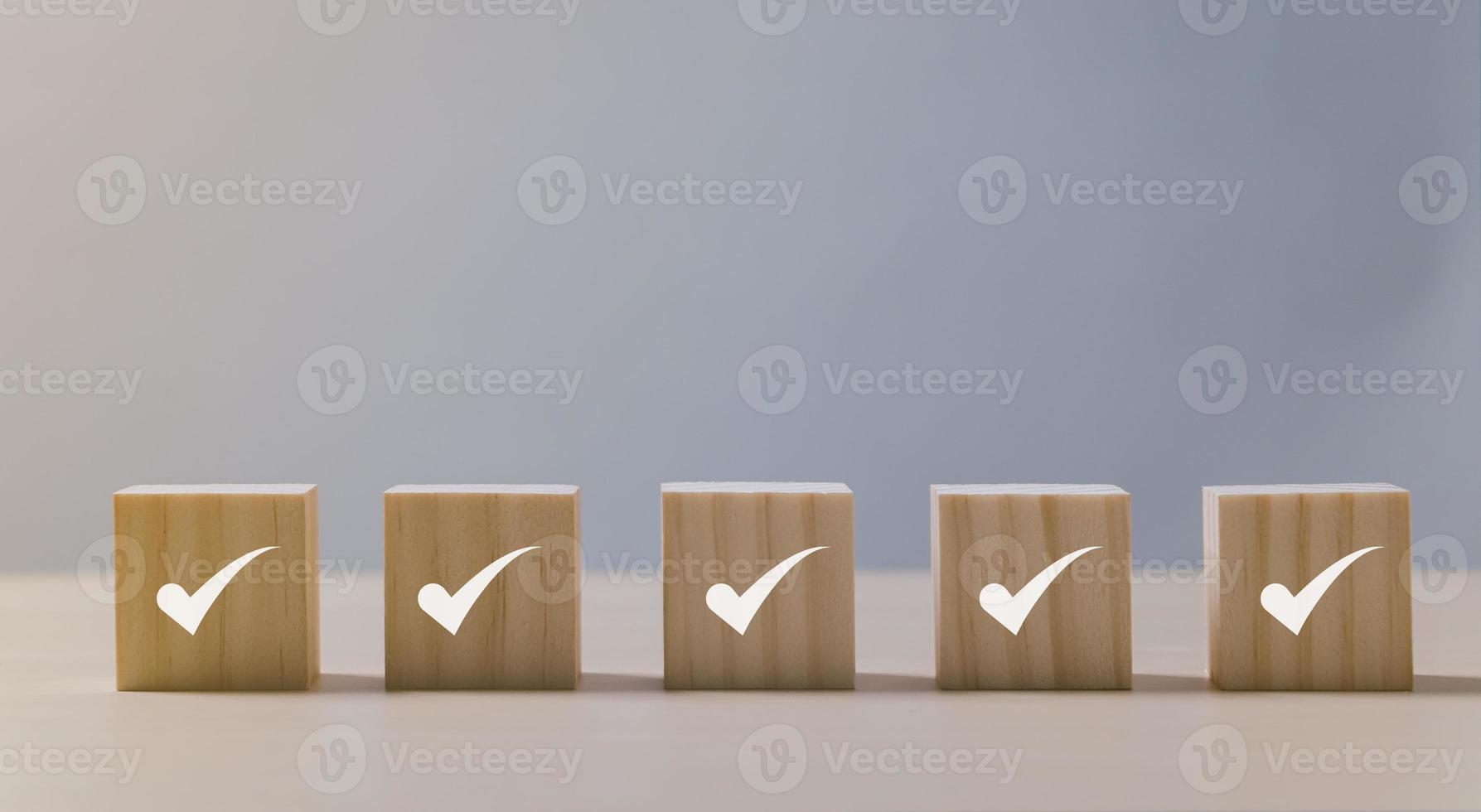 Checklist Survey and assessment concept, Checkmark icon on wooden blocks, gray background with copy space photo