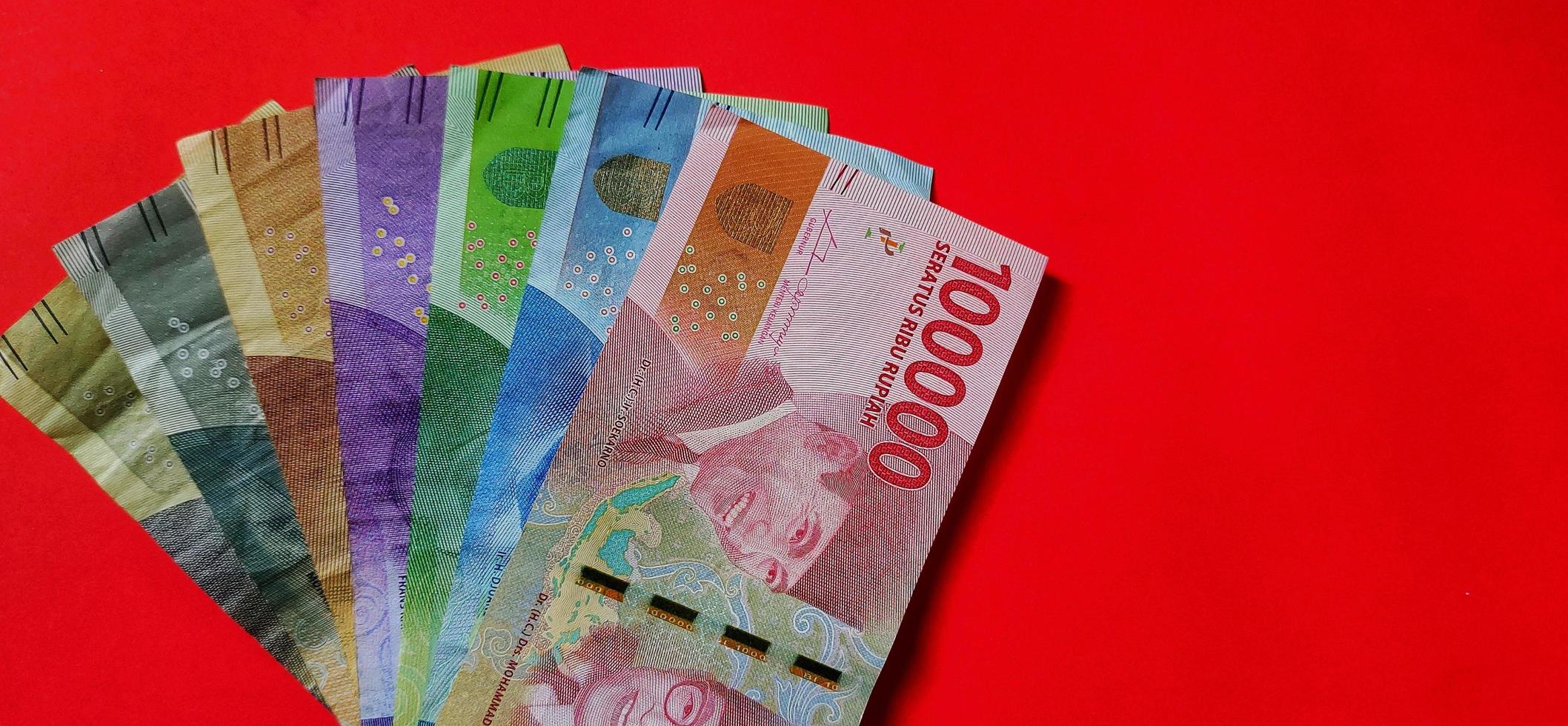Indonesian Rupiah. Collection of banknotes Indonesian rupiah isolated on red background. Negative space photo