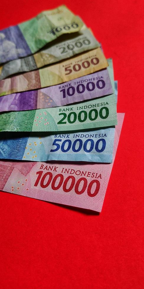 Portrait of Indonesian Rupiah. Collection of banknotes Indonesian rupiah isolated on red background. photo