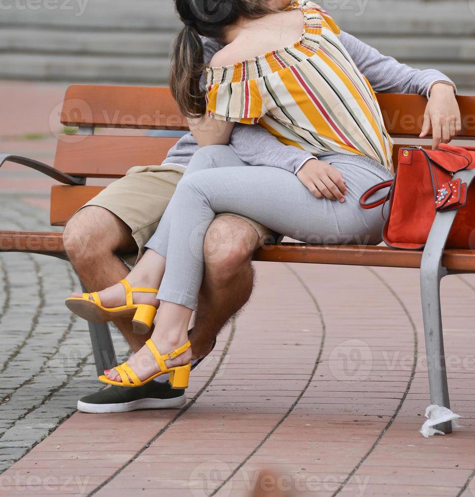 two young lovers resting on a bench on the street photo