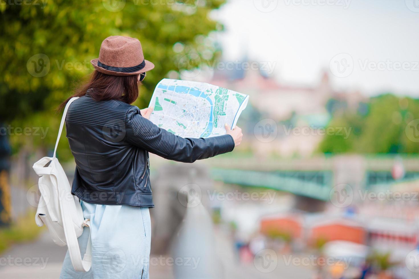 Beautiful woman with touristic citymap in the city. Happy girl enjoy european vacation holiday in Europe. photo