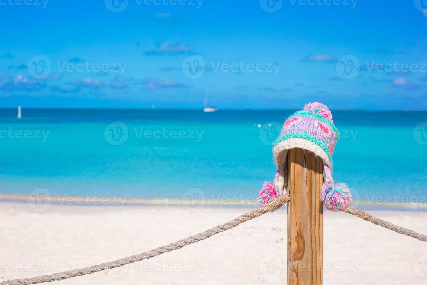 primer plano gorro de punto cálido en la valla en la playa tropical foto