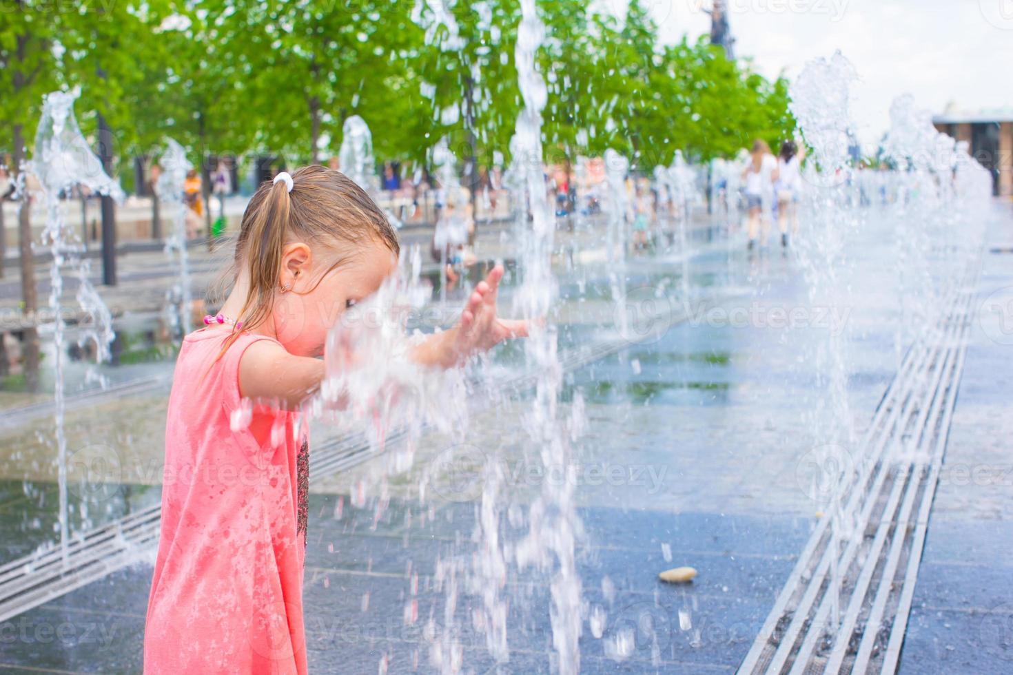 Adorable little girl have fun at hot sunny summer day photo