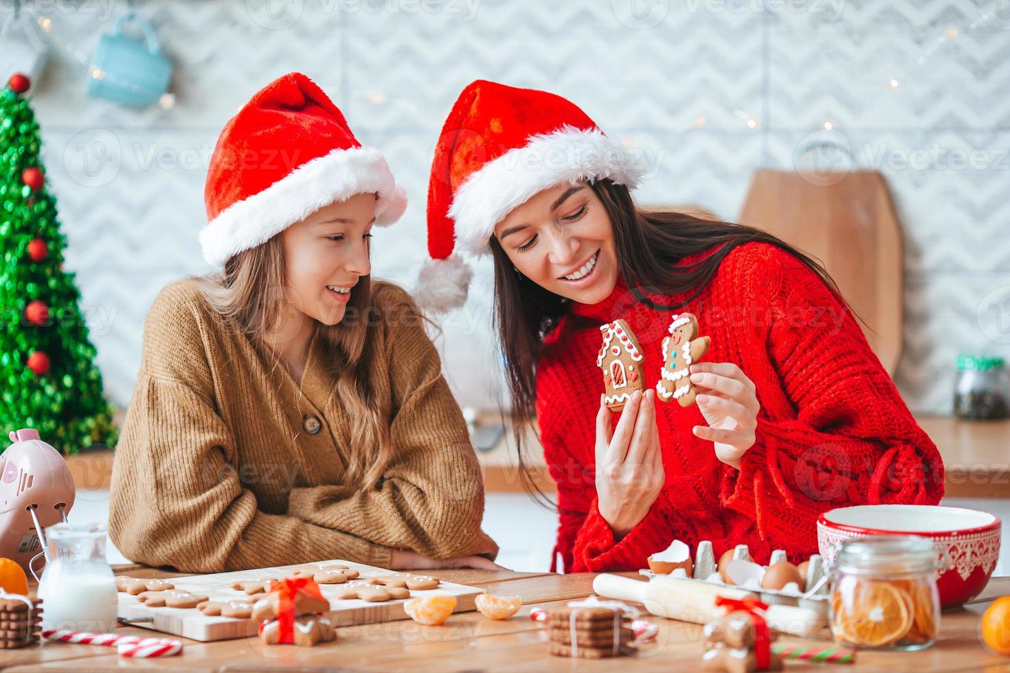 familia feliz madre e hija hornean galletas para navidad foto