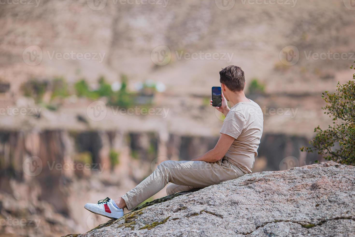 Tourist man outdoor on edge of cliff seashore photo