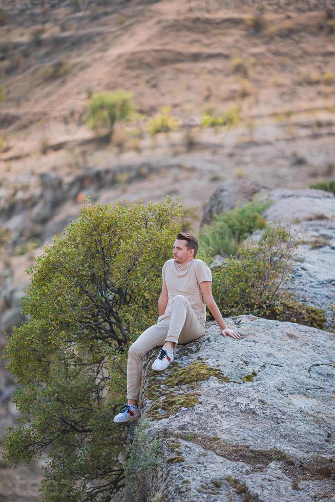 Tourist man outdoor on edge of cliff seashore photo