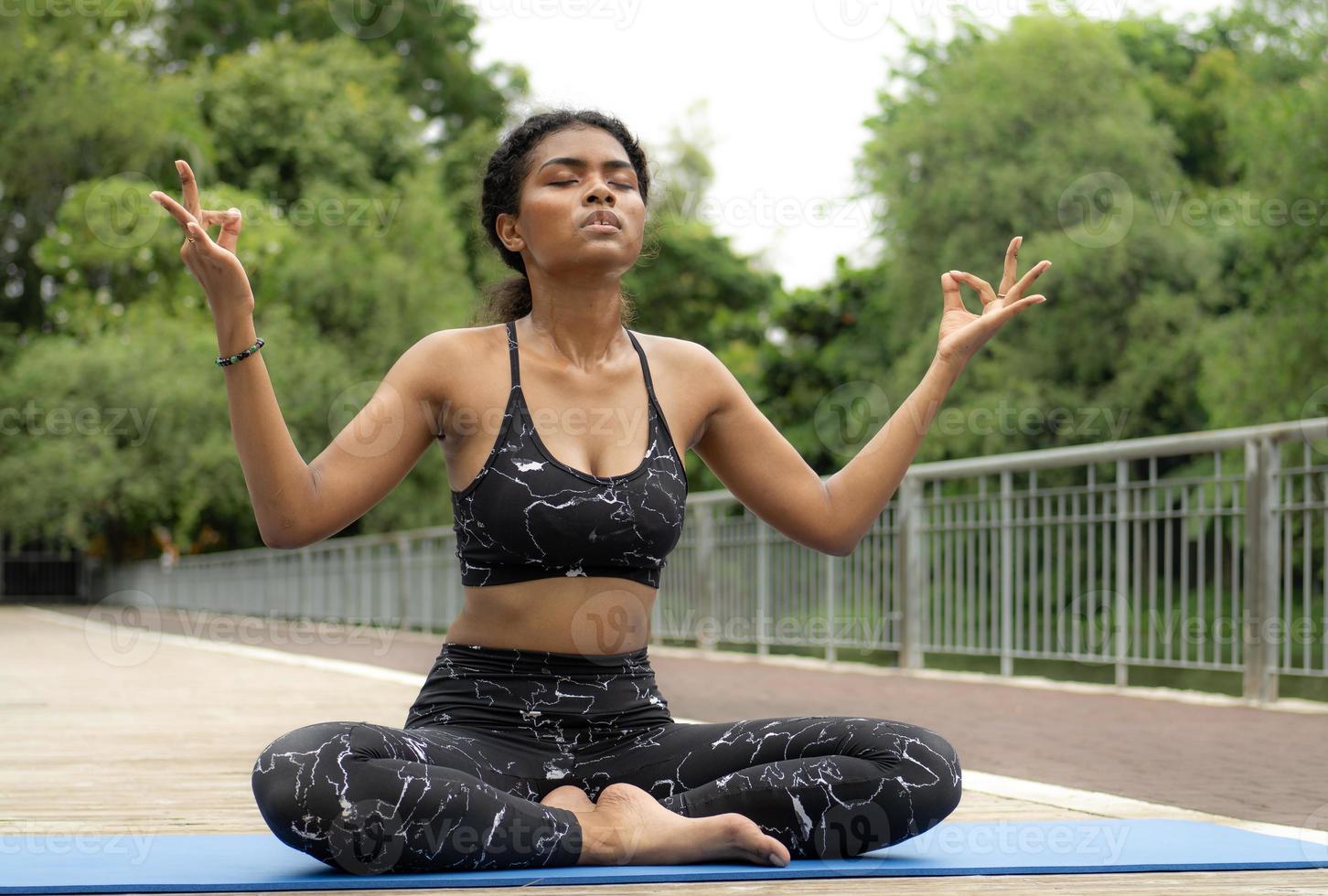 Beautiful woman practicing yoga outdoor in the tranquil nature park. Female person leisure activity is meditation, relaxation mindfulness exercise for healthy lifestyle and peaceful spirituality. photo