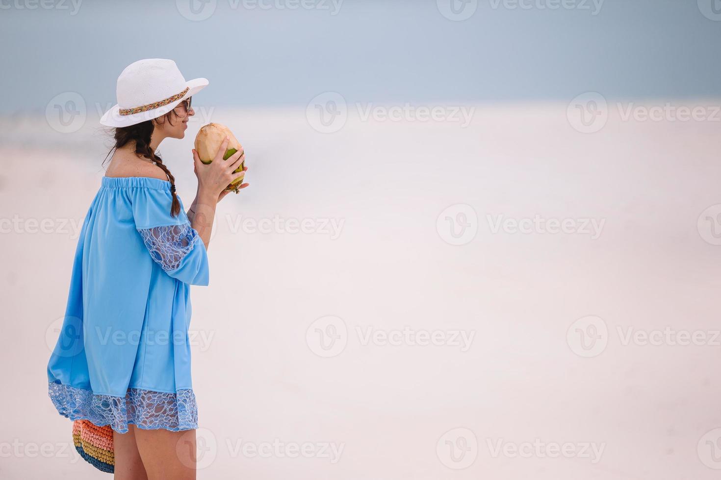 Young woman drinking coconut milk during tropical vacation photo