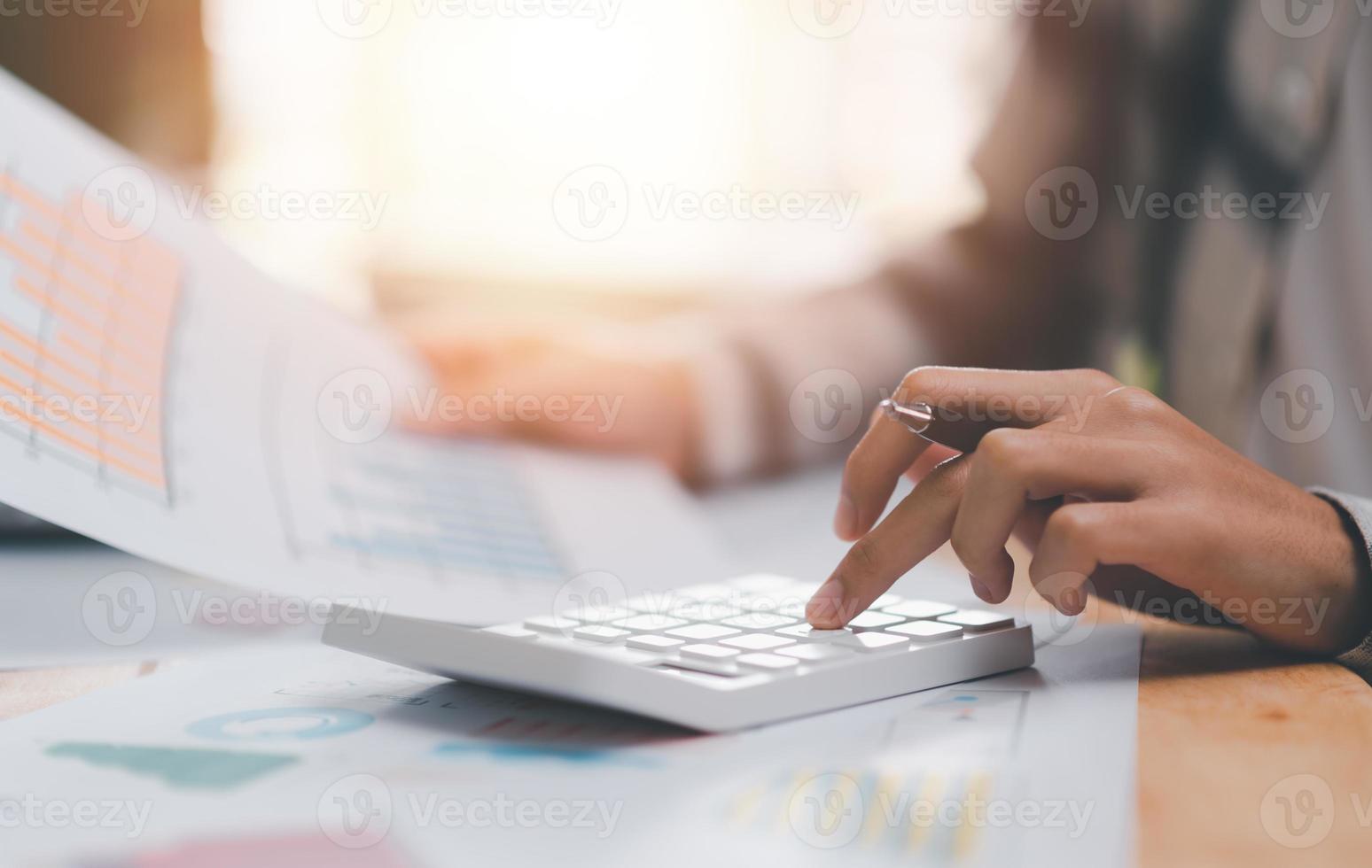 Businessman calculating figures in company financial documents with a calculator,analysis of company financial data,Planning to assess and review budgets,concept of finance and investment photo