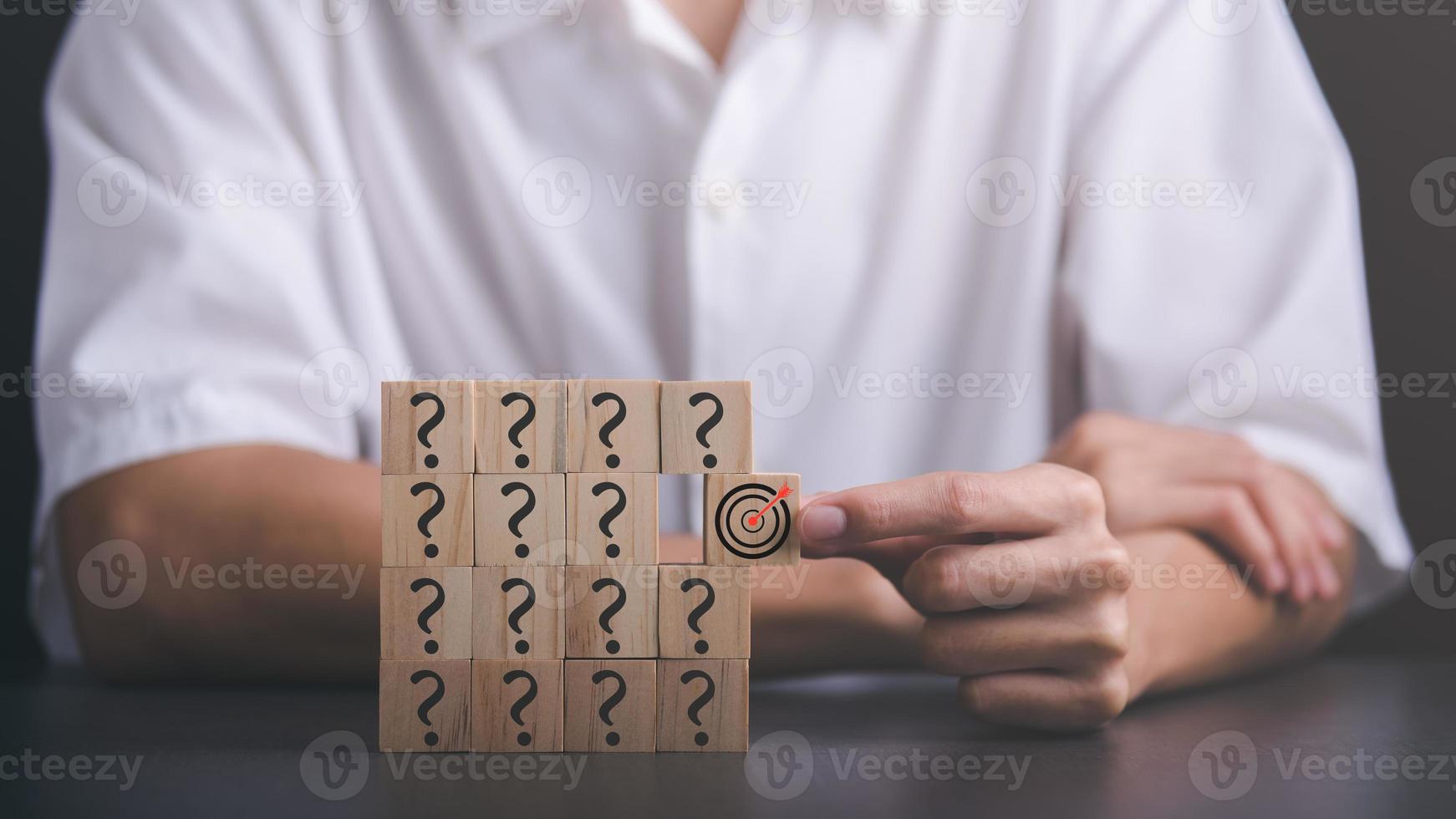 Wooden block in businessman hand and arrow icon hitting center of dartboard target,Setting business goals and focused concepts, Organizational growth and objectives, marketing strategy planning photo