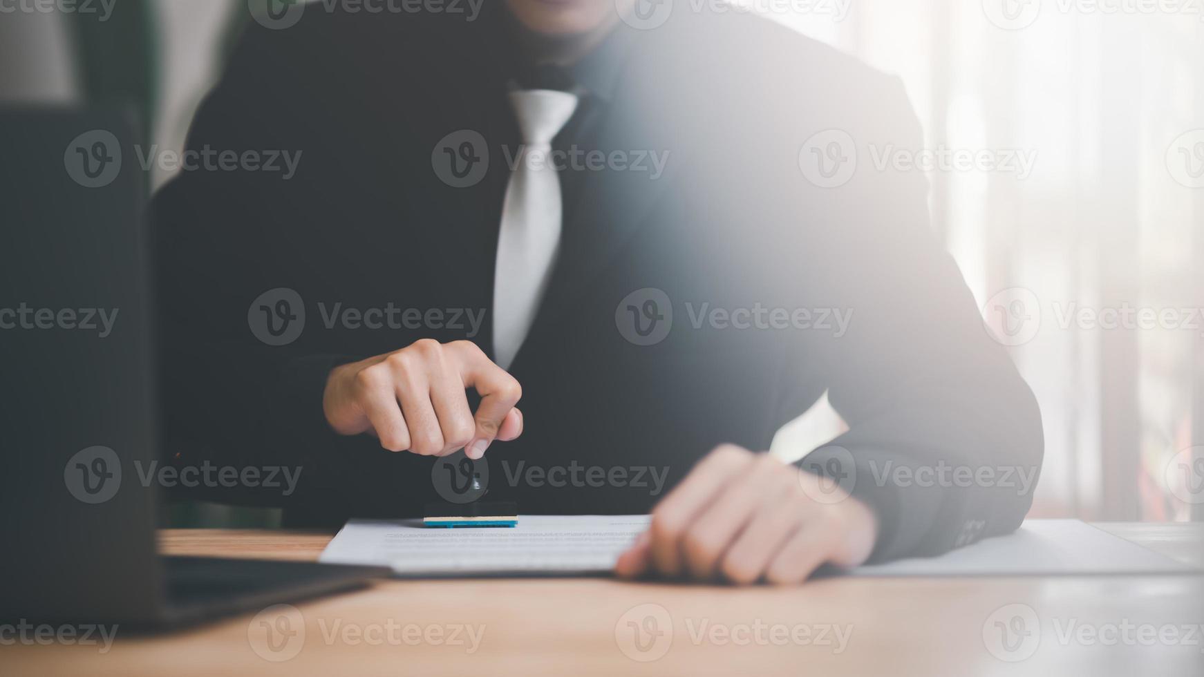 Businessman validates and manages business documents and agreements, signing a business contract approval of contract documents confirmation or warranty certificate,approval stamp,business contract photo