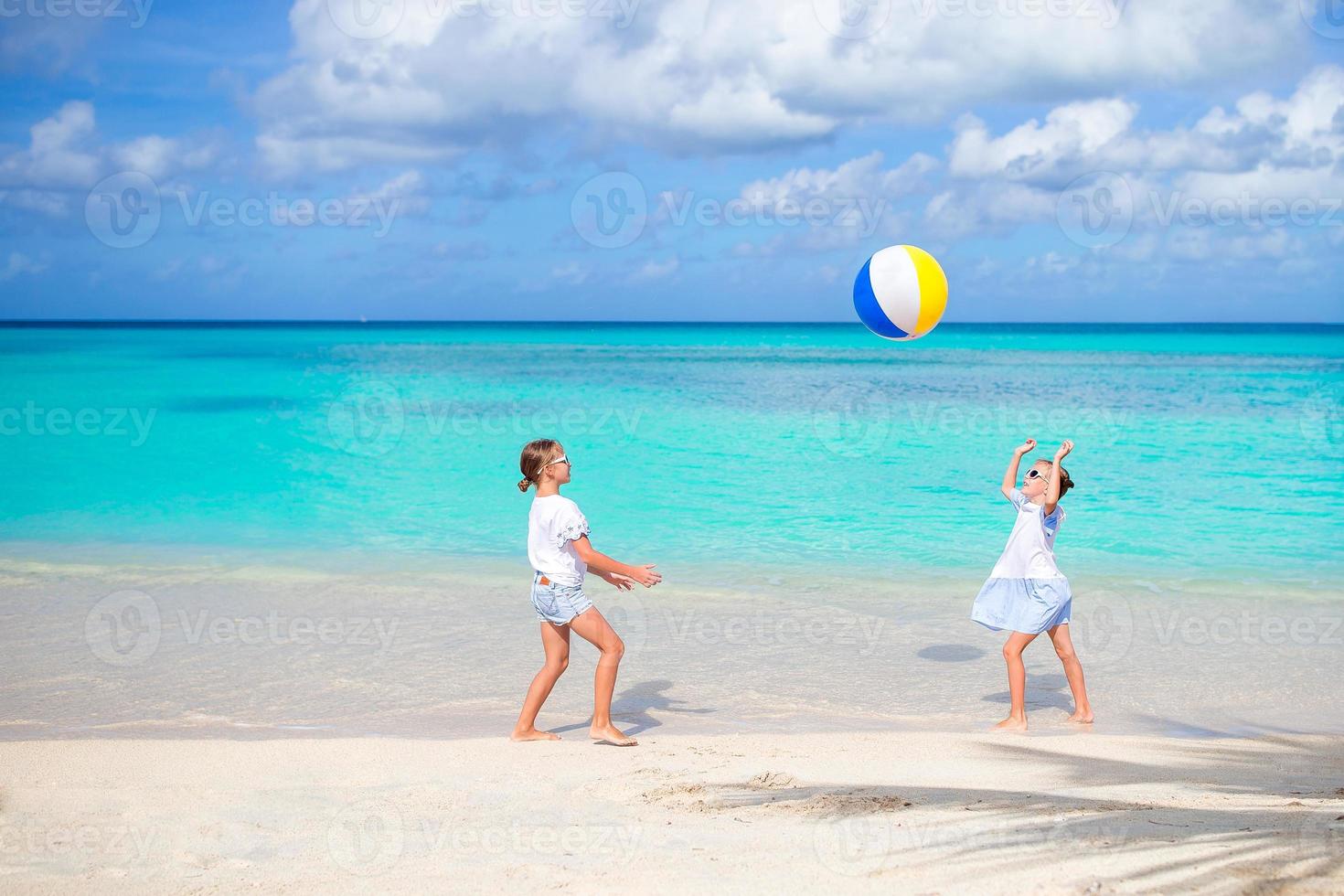 niñas adorables jugando con pelota en la playa foto