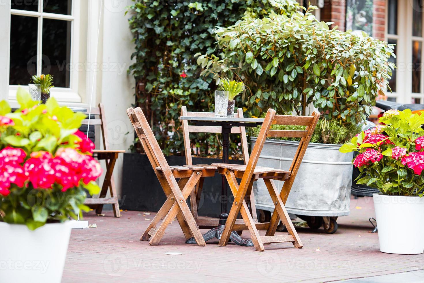 Outdoor cafe on a street of typical greek traditional village in Greece. Coffee on table for breakfast photo